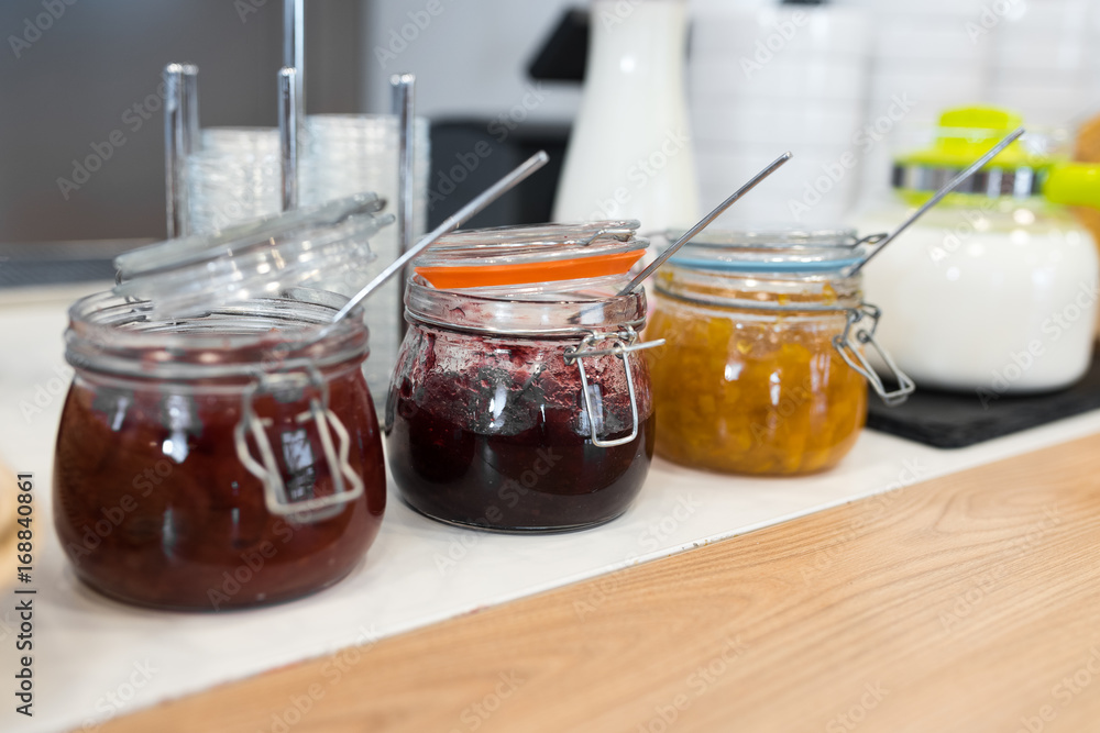 Breakfast in hotel, catering buffet. Glass filed with fruit jam Breakfast in hotel, catering buffet. Glass filed with fruit jam