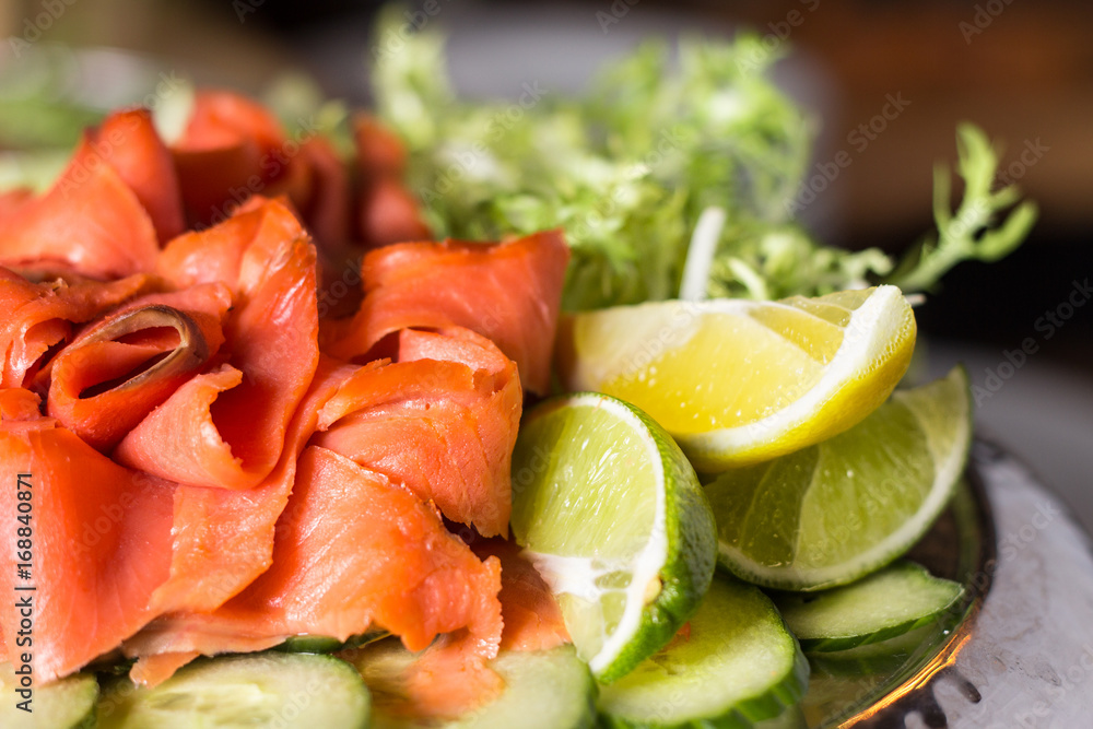 Plated smoked salmon accompanied by lime and lemon wedges. Plated smoked salmon accompanied by lime and lemon wedges.