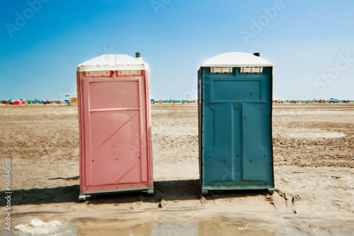 Portable unisex toilets on the beach.