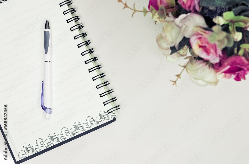 Top or flat lay view of eyeglass and notebook with flower decoration on white table background with copy space. Top or flat lay view of eyeglass and notebook with flower decoration on white table background with copy space.