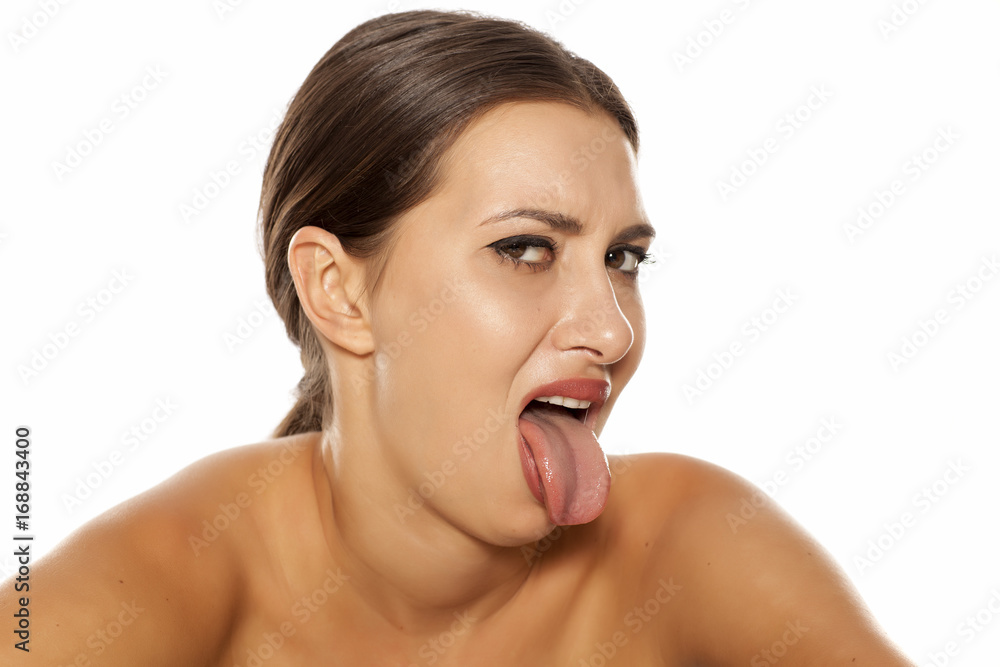 young woman with negative expression shows her tongue out young woman with negative expression shows her tongue out