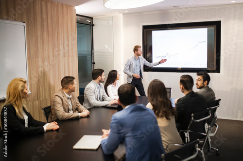 Young attractive businessman showing presentation to his colleagues