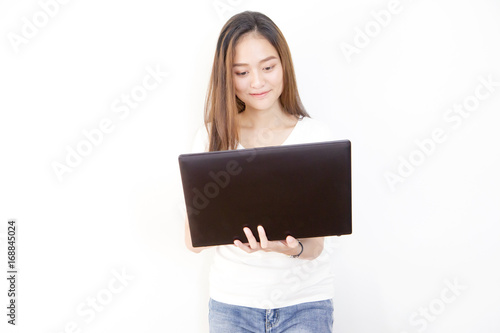 young Asian woman standing and using laptop computer with smiling face on white background.