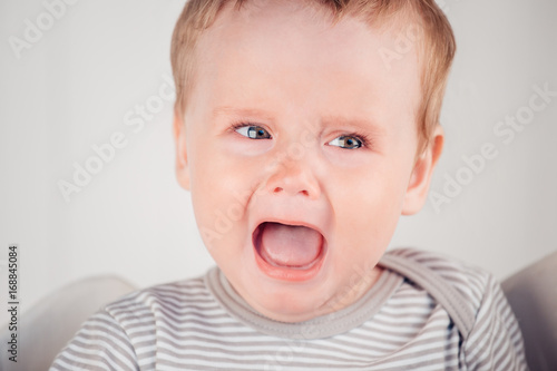 Photos The crying boy, on white wall on bed