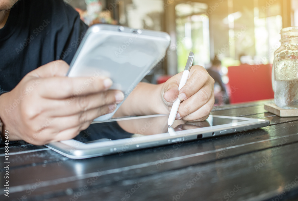 Obraz premium Businesswoman holds a white smartphone or smart device on her right hand and a stylus pen on the left hand, chats with friends via an instant messaging app over the public internet. Internet concept.
