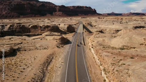 Two motorcycle riders driving over a bridge across a canyon in USA
