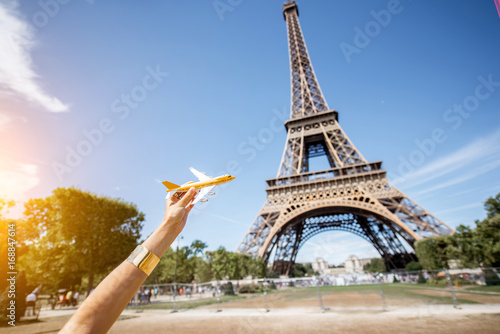 Holding a toy airplane on the Eiffel tower background. Air connection and tourism concept in Paris © rh2010