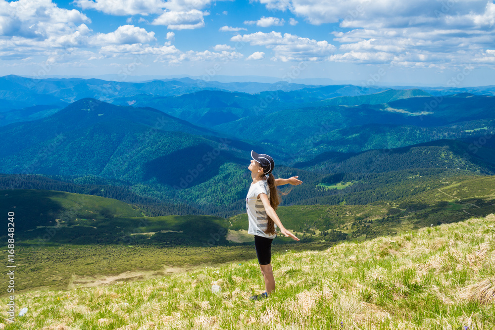 Young woman on the peak of the mountain raise up hand and enjoy beautiful view of sky and mountains. Success concept. Freedom concept Young woman on the peak of the mountain raise up hand and enjoy beautiful view of sky and mountains. Success concept. Freedom concept
