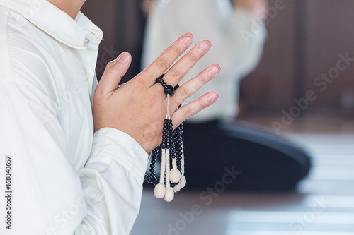Prayer and holding prayer book and jutsu beads in japanese buddhist nichiren or shinto culture religion