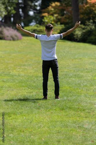 Teenage boy with his arms outstreched on a summer's day