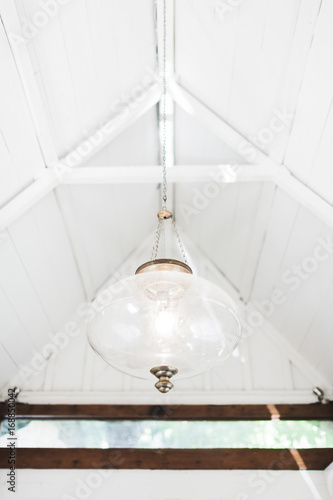 White vintage glass lamp in white interior of wooden house