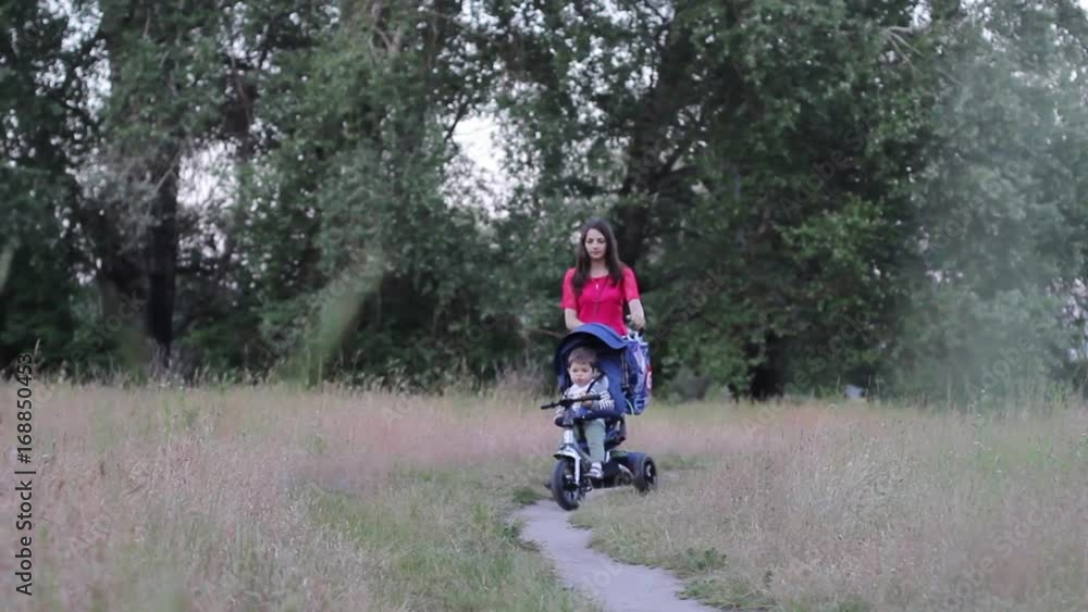 Mother with a baby in a stroller on a walk in the forest Mother with a baby in a stroller on a walk in the forest