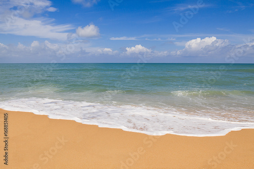 Sandy beach with soft wave on cloudy blue sky background in Phuket, Thailand