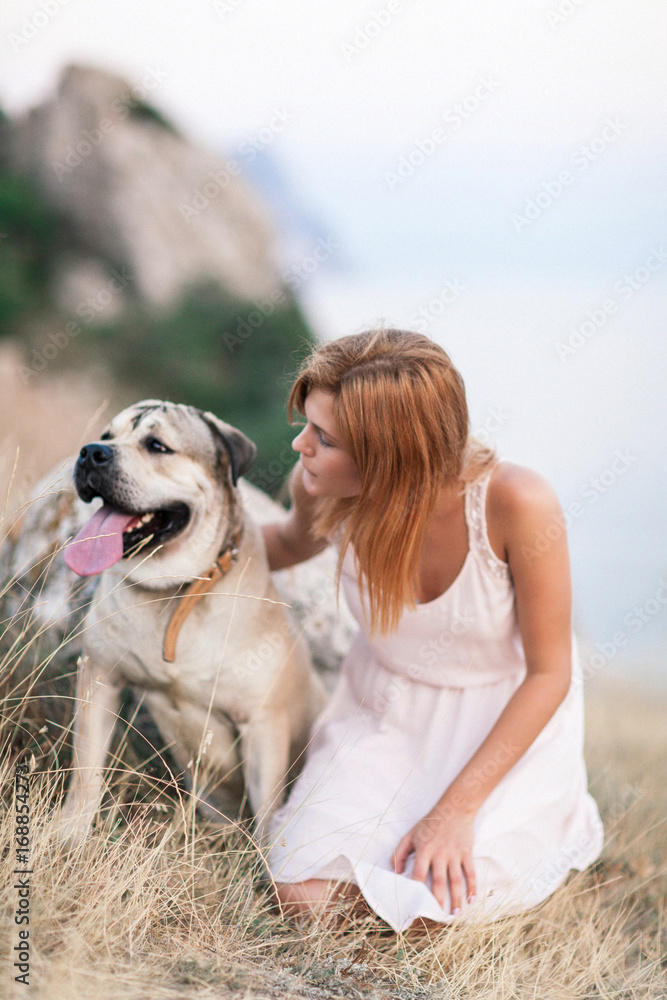 Young caucasian woman walking with dog during sunrise Young caucasian woman walking with dog during sunrise