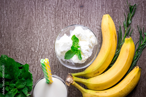 Ice cream with fresh banana and mint on wooden table.