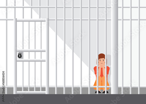Stressed woman sitting on floor in the corner of jail.
