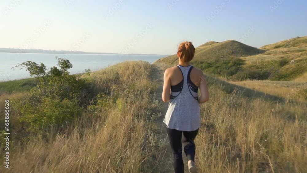 Beautiful girl doing morning jogging at sunrise in the field. outdoors fitness Beautiful girl doing morning jogging at sunrise in the field. outdoors fitness
