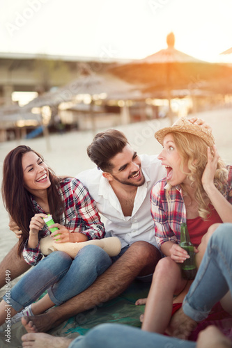 Group of cheerful friends having great time at beach