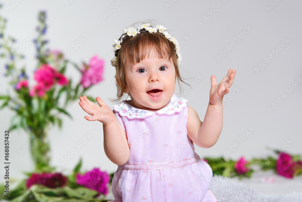 Little girl in a pink dress sitting with a bouquet of pink flowers Little girl in a pink dress sitting with a bouquet of pink flowers