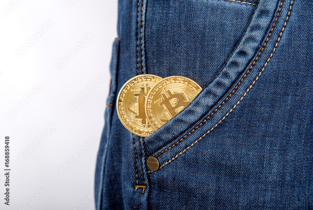 Two gold bitcoin in man pocket jeans. Two gold bitcoin in man pocket jeans.