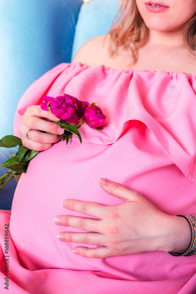 Woman expecting a baby in pink dress Woman expecting a baby in pink dress