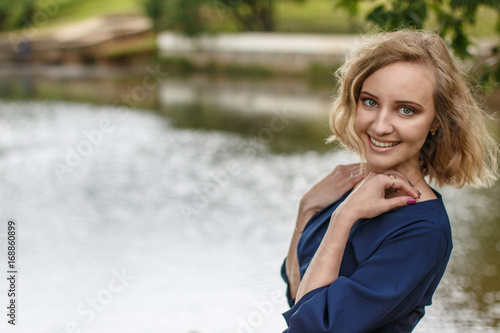Portrait attractive girl with blond hair in a park © keleny