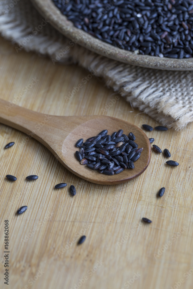 Black rice in a wooden plate. Closeup.
