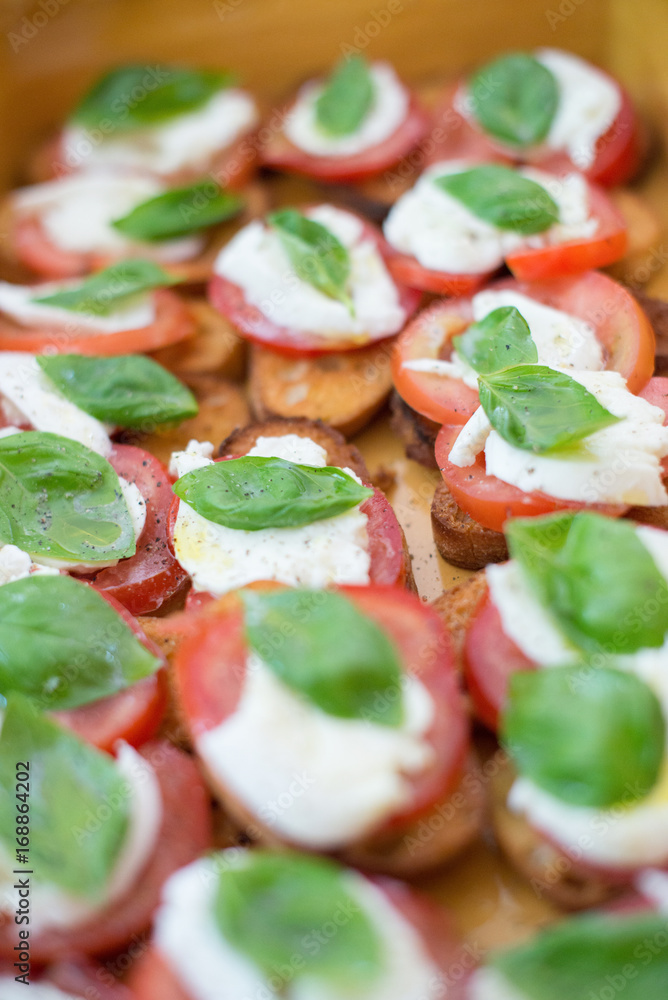Bruschetta Caprese, toast with tomato, mozzarella and basil, Italian dish Bruschetta Caprese, toast with tomato, mozzarella and basil, Italian dish