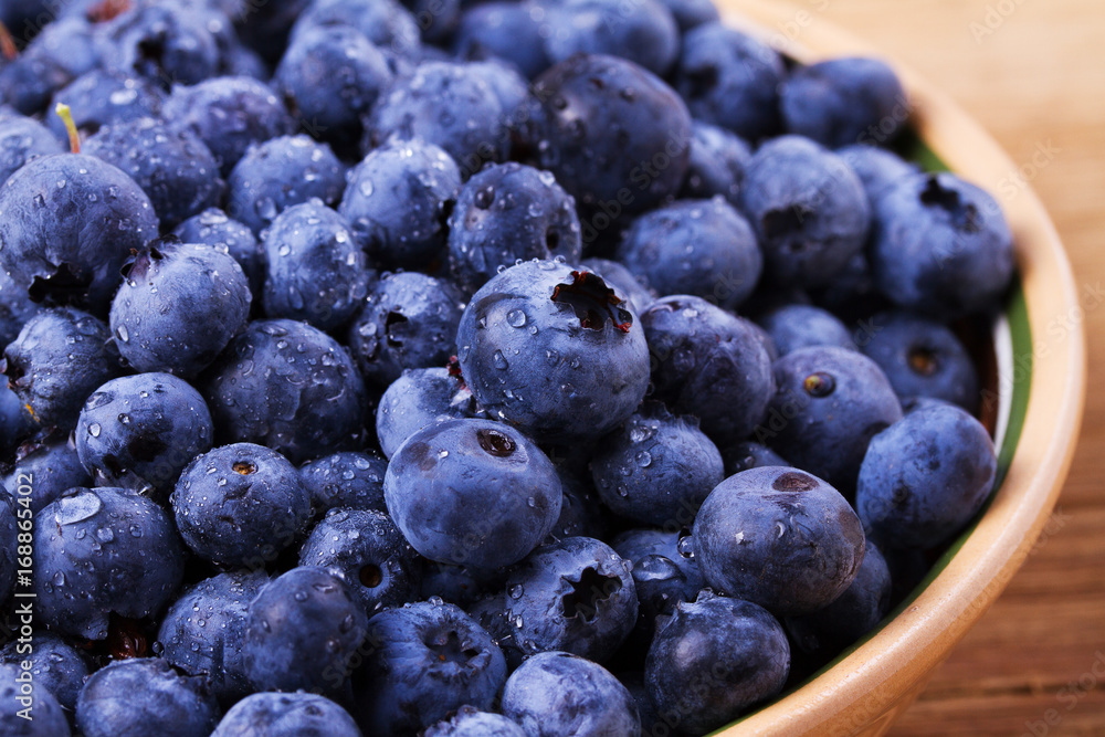 Blueberries in clay bowl. Freshly picked berries on rustic background. Blueberry antioxidant superfood, concept for healthy eating Blueberries in clay bowl. Freshly picked berries on rustic background. Blueberry antioxidant superfood, concept for healthy eating