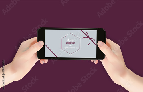 Person hält Smartphone mit weihnachtlicher Grußkarte