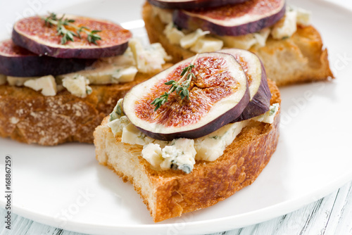 toast with figs and blue cheese on a plate, closeup