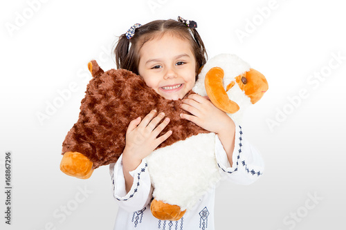 Happy little girl playing with her sheep toy - celebrating Eid ul Adha - Happy Sacrifice Feast photo