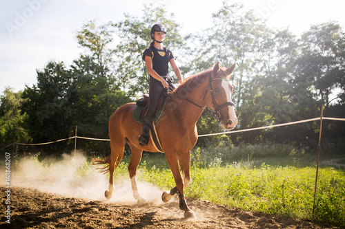 Portrait of young woman riding horse in countryside