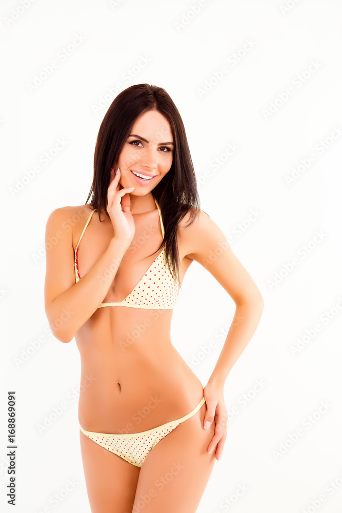 Portrait of attractive charming smiling brunette, showing her perfect body in a swimming suit isolated on the white background Portrait of attractive charming smiling brunette, showing her perfect body in a swimming suit isolated on the white background