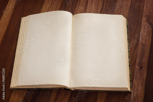Open blank old book on wooden background