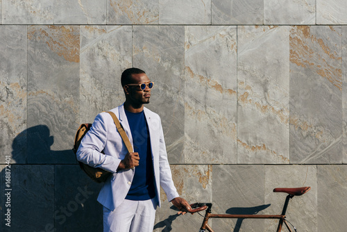 Trendy man with bicycle at street photo