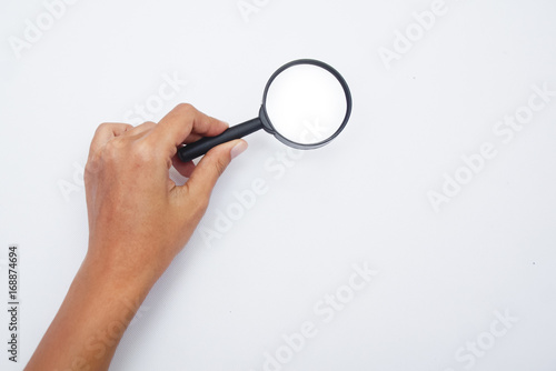 Hand Holding Magnifying Glass Over White Background