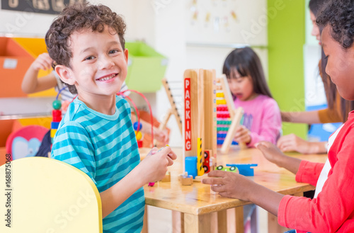 Foto Kindergarten students smile when playing toy in playroom at preschool internatio