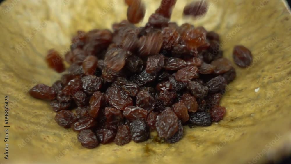Black raisins falling in super slow motion - closeup Black raisins falling in super slow motion - closeup
