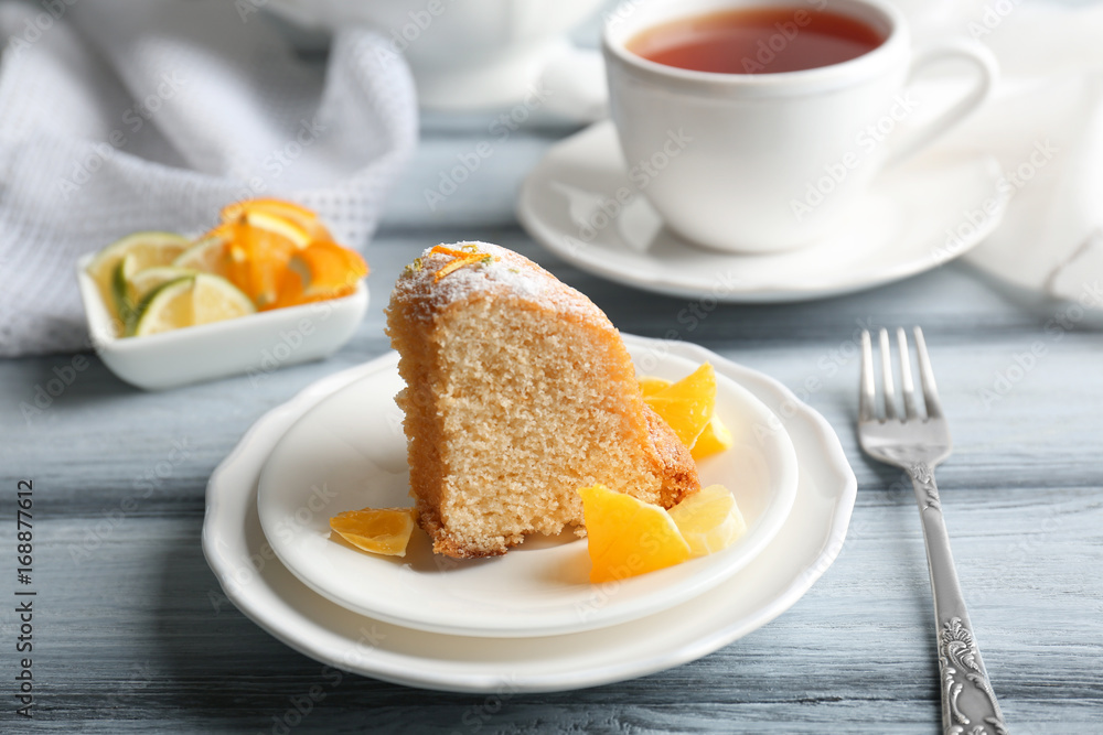 Plates with delicious cake and sliced citrus fruits on wooden table Plates with delicious cake and sliced citrus fruits on wooden table