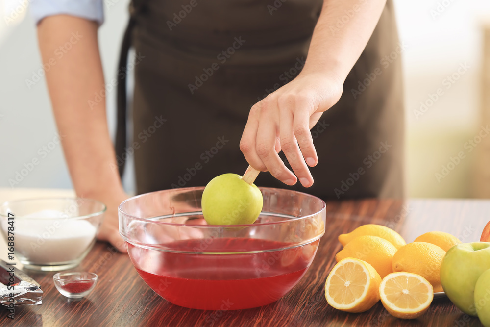 Young woman preparing toffee apples in kitchen Young woman preparing toffee apples in kitchen