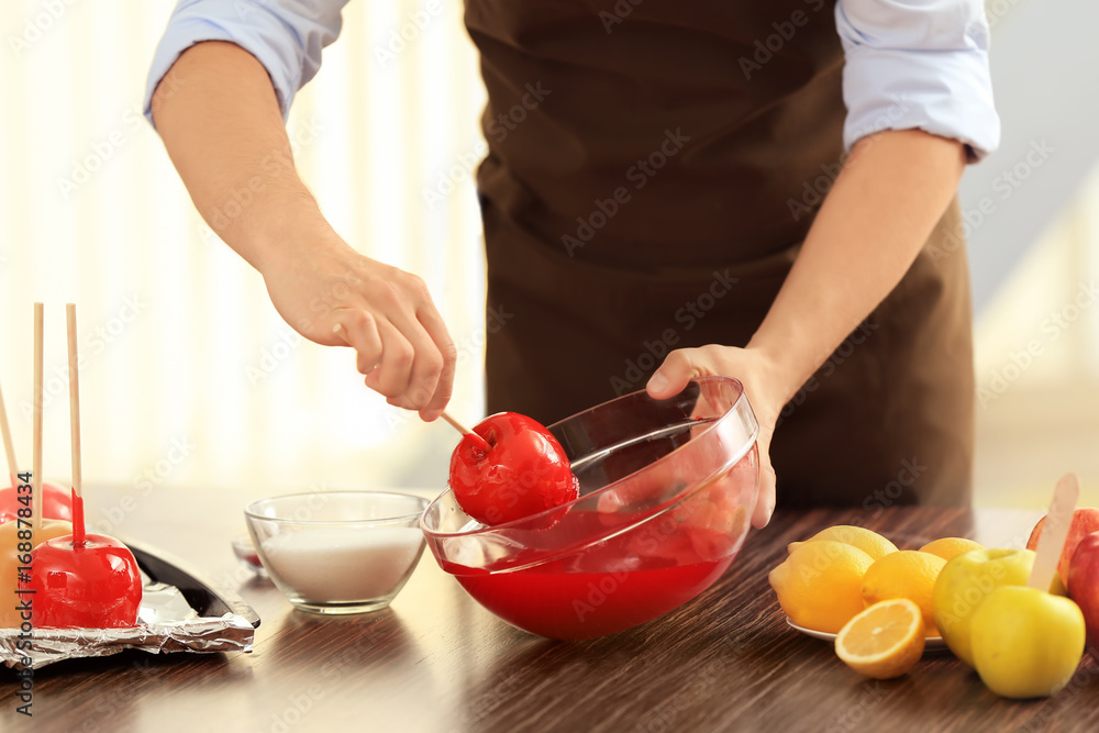Young woman preparing toffee apples in kitchen