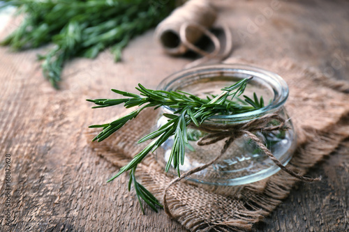 Jar with fresh rosemary on table