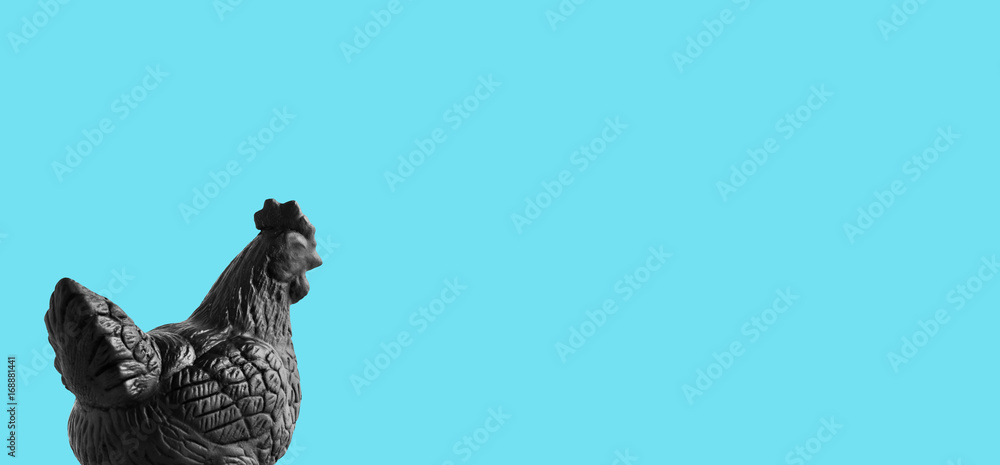 Fototapeta premium black color painted female bantum plaster sculpture on light blue background, copy space on rigth