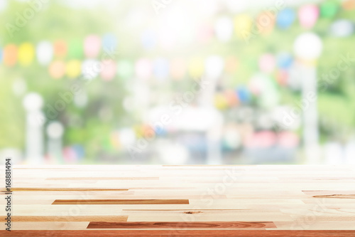 Canvas Print Empty wooden table with party in garden background blurred.