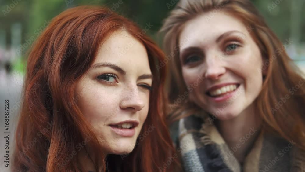 Redhead Friends taking selfie with a smart phone and making faces and fun. 20s Redhead Friends taking selfie with a smart phone and making faces and fun. 20s