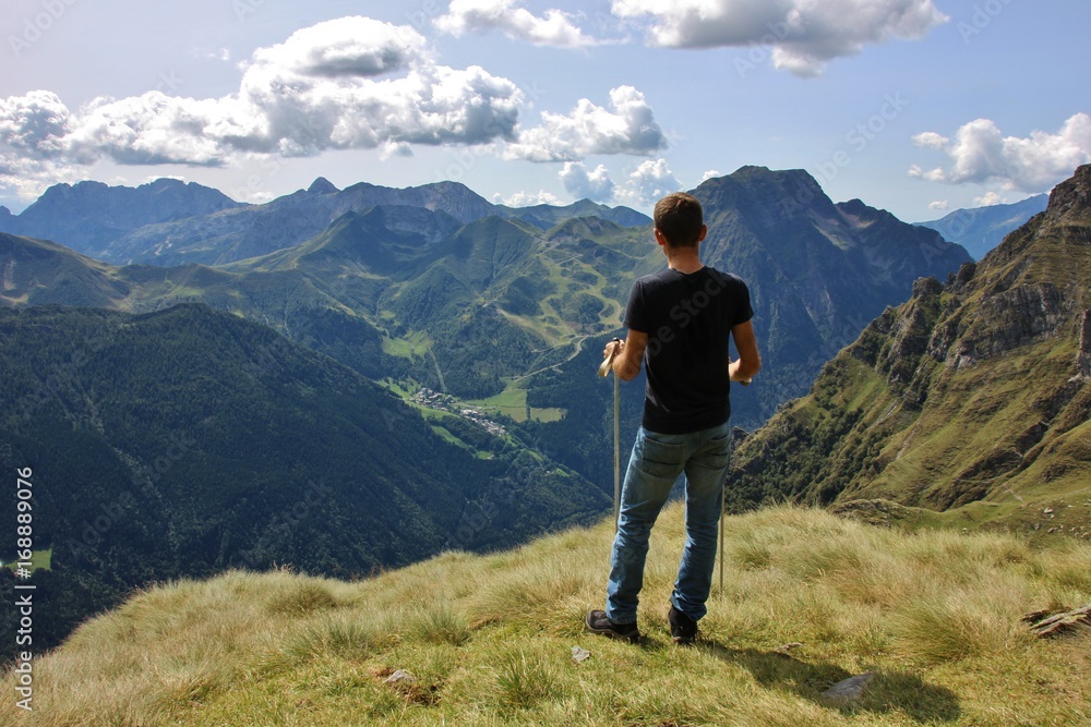 Hiker enjoying the view on Orobie Alps over Seriana Valley, Bergamo, Italy Hiker enjoying the view on Orobie Alps over Seriana Valley, Bergamo, Italy