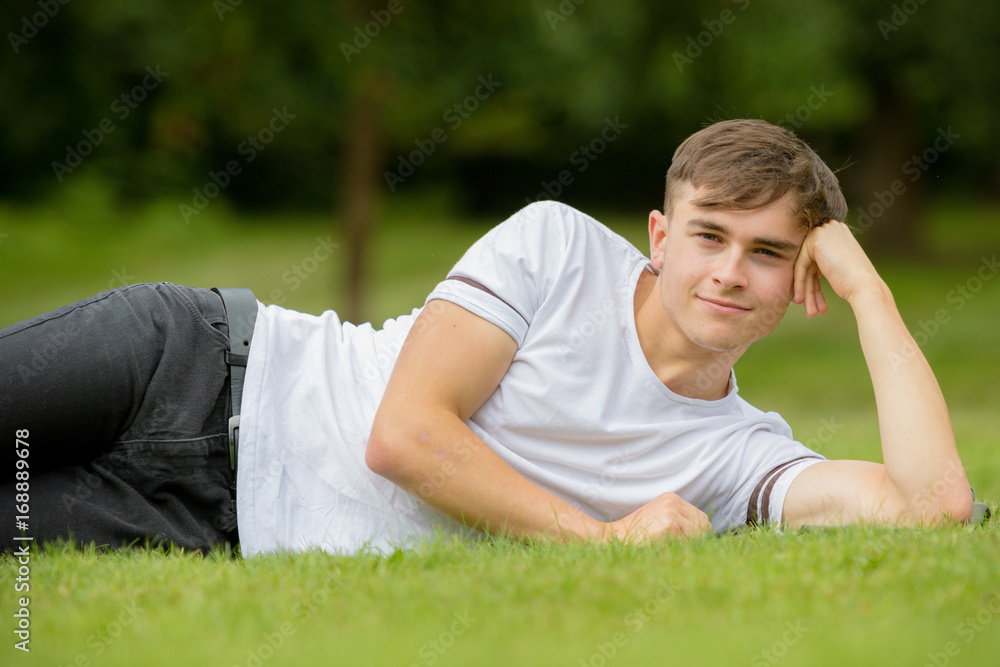 Teenage boy laying on grass on a summers day Teenage boy laying on grass on a summers day