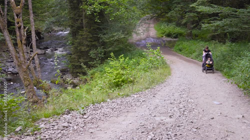 Mother with a stroller goes on offroad Mother with a stroller goes on offroad