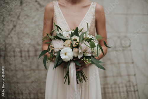 Bohemian indie bride in simple sparkle top wedding dress and feminine pastel bouquet with ribbon